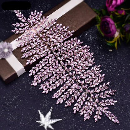 Pink leaf bridal crown displayed on a gift box with sparkling background.