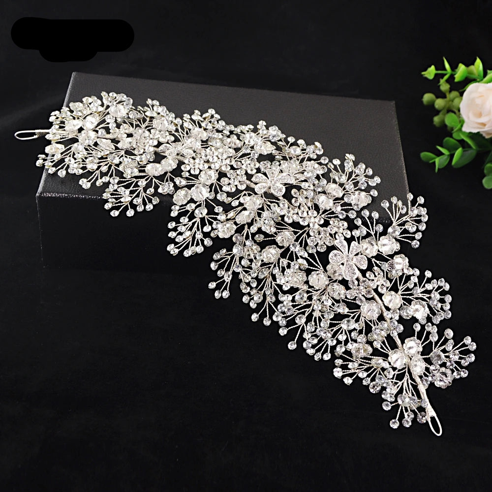 Floral rhinestone bridal hairpiece with intricate silver flowers and crystal branches laid flat.