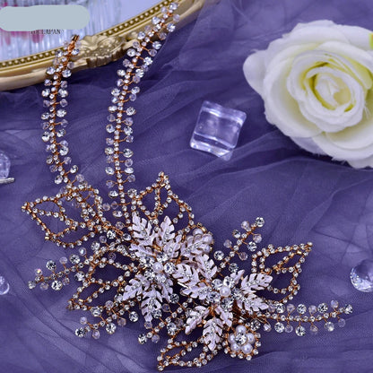 Rose gold floral bridal headpiece with sparkling crystal strands and leaf design displayed flat on fabric