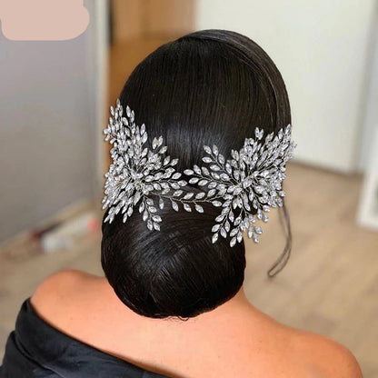 Bride wearing double silver floral tiara on sleek bun hairstyle.