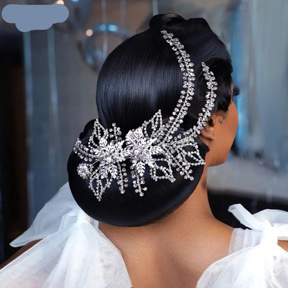 Bride wearing silver bridal tiara with pearl detailing and sweeping crystal vines on a smooth bun