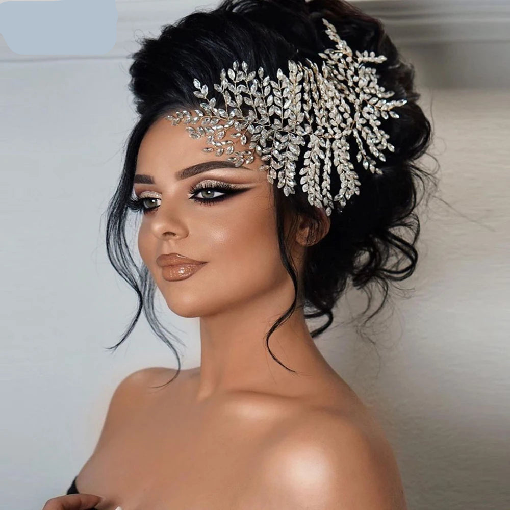 “Bride wearing silver crystal leaf crown tiara as a statement accessory with voluminous hairstyle.