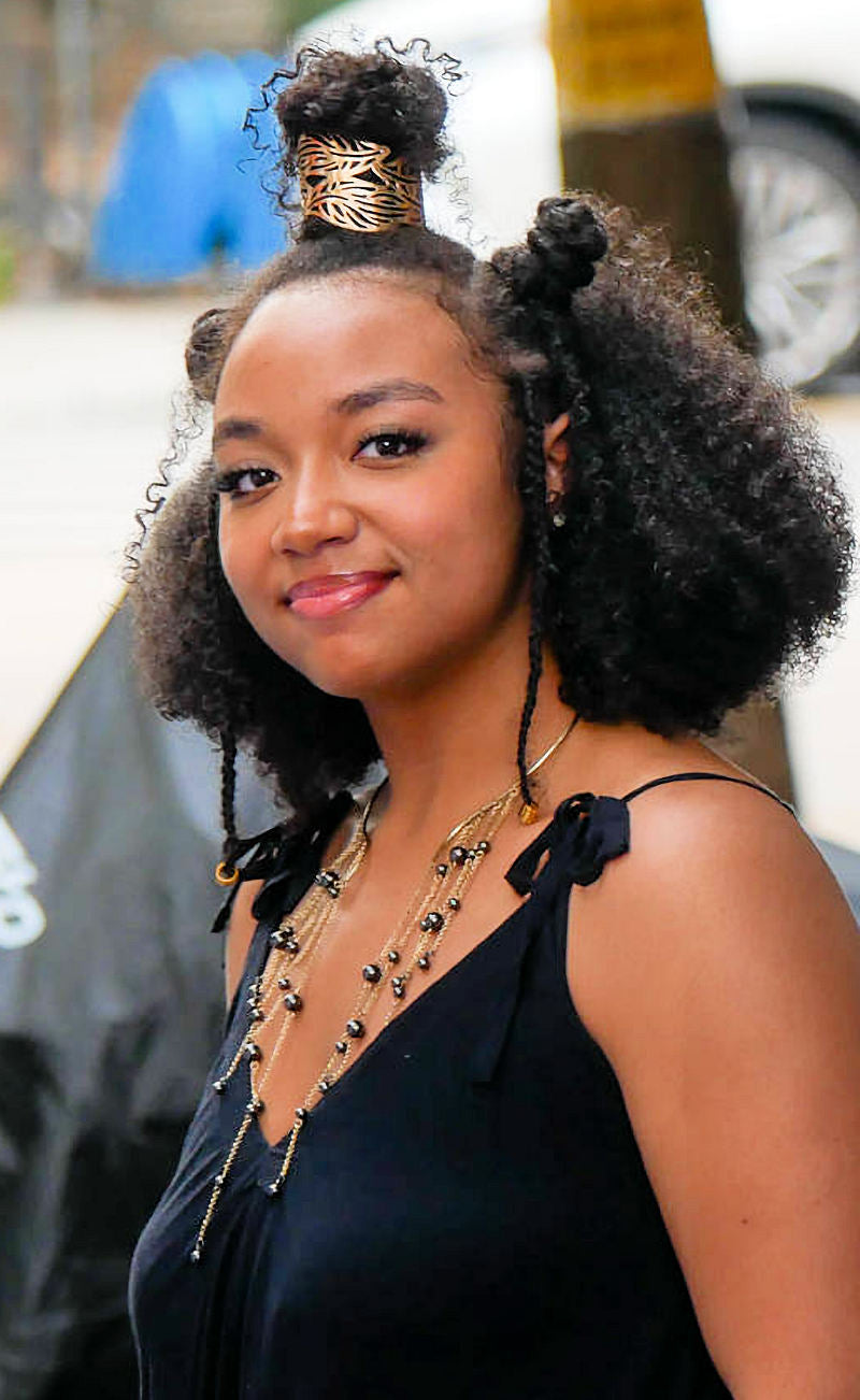 Woman with styled hair and black top outdoors