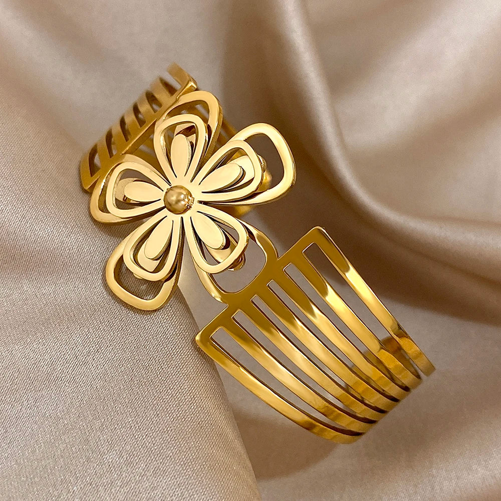 Shiny gold hair cuff with floral centerpiece and open comb-like sides, displayed diagonally.