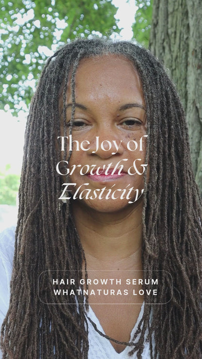 Smiling woman with long, healthy locs promoting What Naturals Love Hair Growth Serum. Strengthens roots and enhances elasticity for vibrant hair.