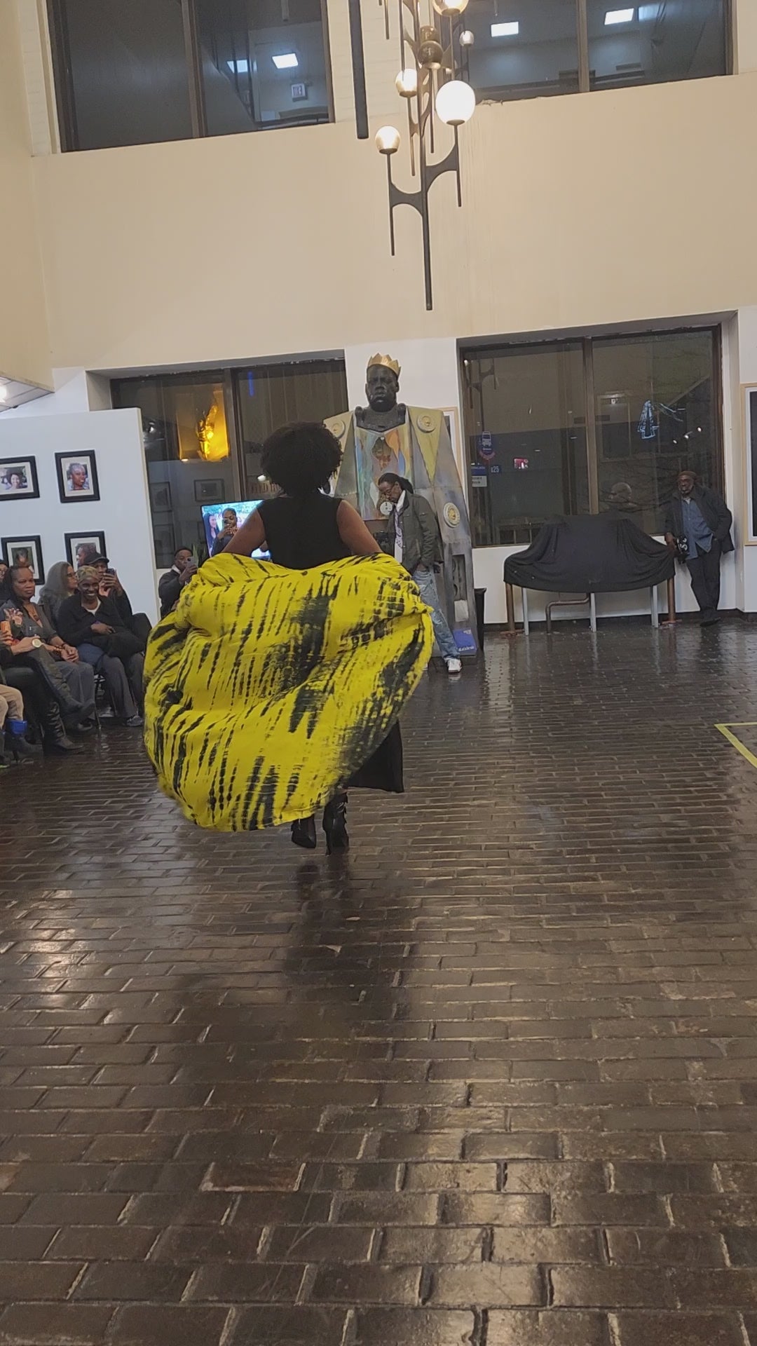 Elegant black maxi dress with pockets, featuring a flowing silhouette and vibrant yellow tie-dye cape. Perfect for spring and summer fashion.