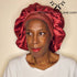Super Comfi Large Satin Bonnet for Locs in deep red, worn by a model. Adjustable, non-elastic design protects braids, locs, and natural hair overnight.